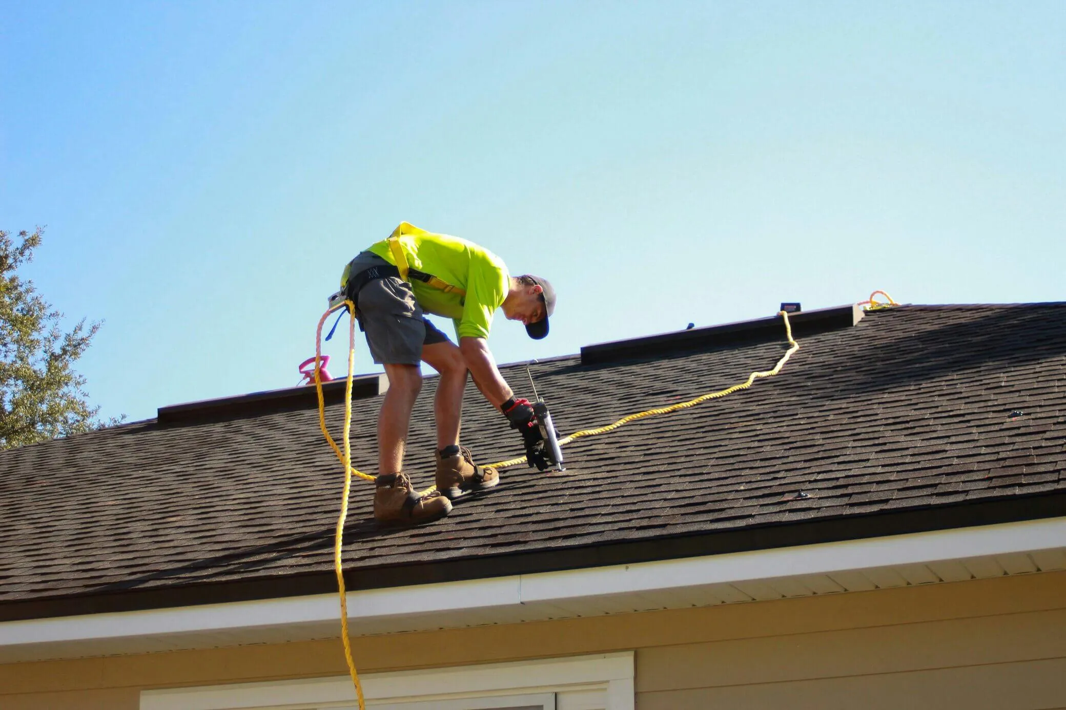 Roofer working on a residential roof on a clear day