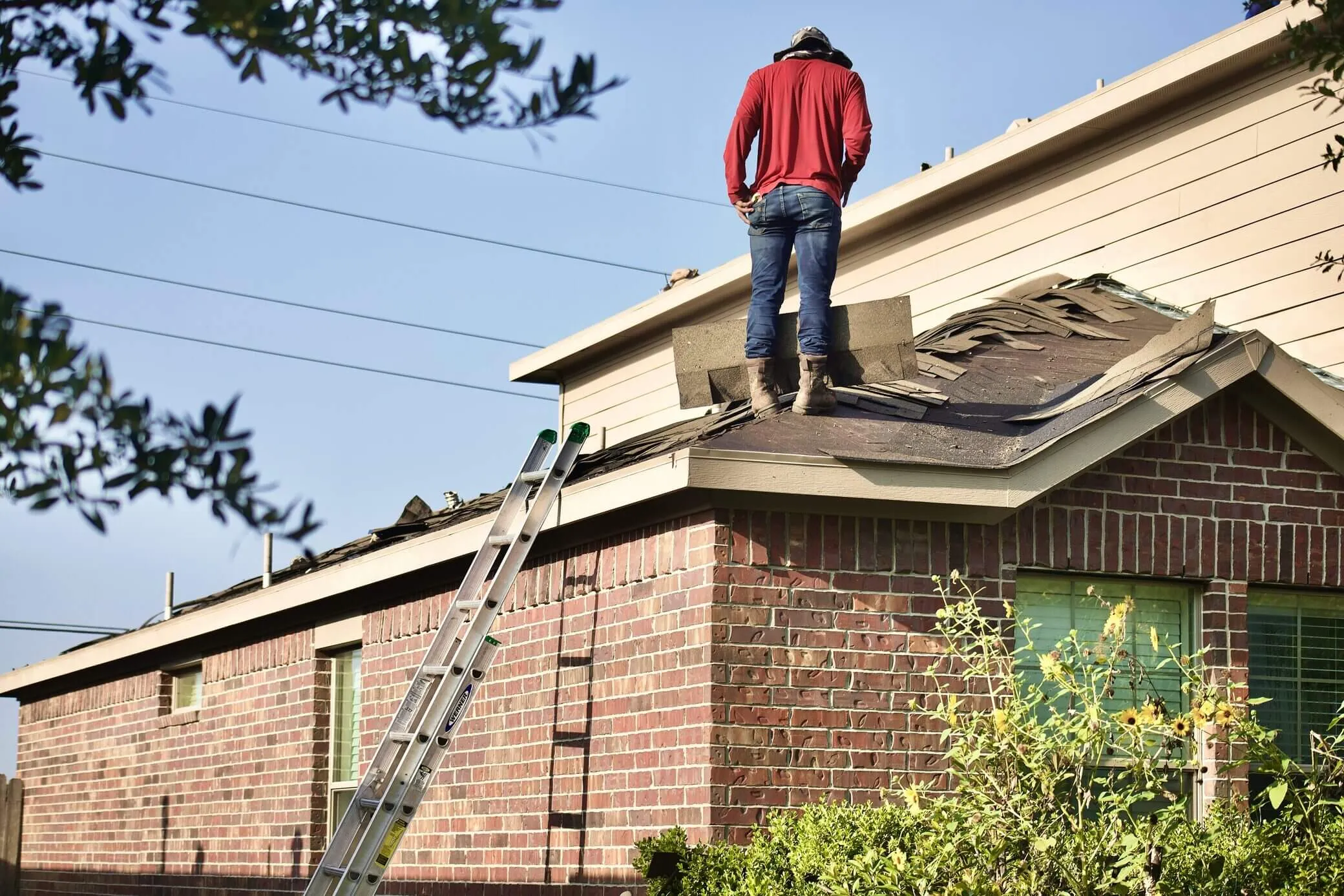 Roofer standing on a residential roof during a repair